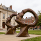 Bronze abstract dual‑head sculpture with smooth elongated forms and hollow circular openings