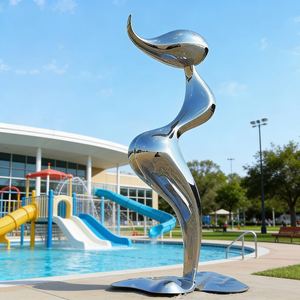 Metallic sculpture in front of a pool with playground equipment in the background