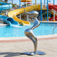 Metallic sculpture in front of a pool with slides in the background