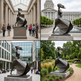 Collage of a sculpture in various outdoor settings including a building, park, and plaza.

Abstract walking‑woman sculpture with smooth angular folds and dynamic movement