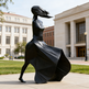 Bronze‑tone abstract woman sculpture with smooth curves and a dynamic walking pose