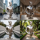 Modern metal artwork depicting a saxophone with emerging hands and a floating human head