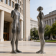 Sleek metallic artwork showing two stylized figures constructed from horizontal ring segments