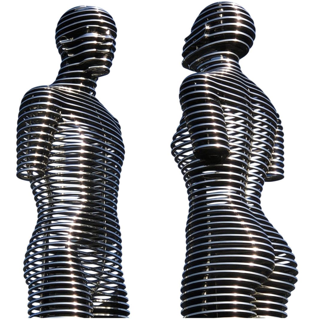 Polished metal sculpture of two human figures formed from stacked circular rings