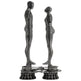 Polished metal ring sculpture depicting stylized human forms in a geometric design