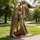 Bronze sculpture of a person playing a guitar in a park setting
Modern abstract embrace sculpture with faceted surfaces and elongated human forms