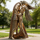 Bronze sculpture of a person holding a book in a park setting
Modern abstract embrace sculpture with faceted surfaces and elongated human forms