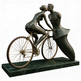 Bronze sculpture of a man and woman kissing on a bicycle
ronze sculpture of a kissing couple with one seated on a bicycle
