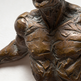 Bronze sculpture of a person holding a child on a white background