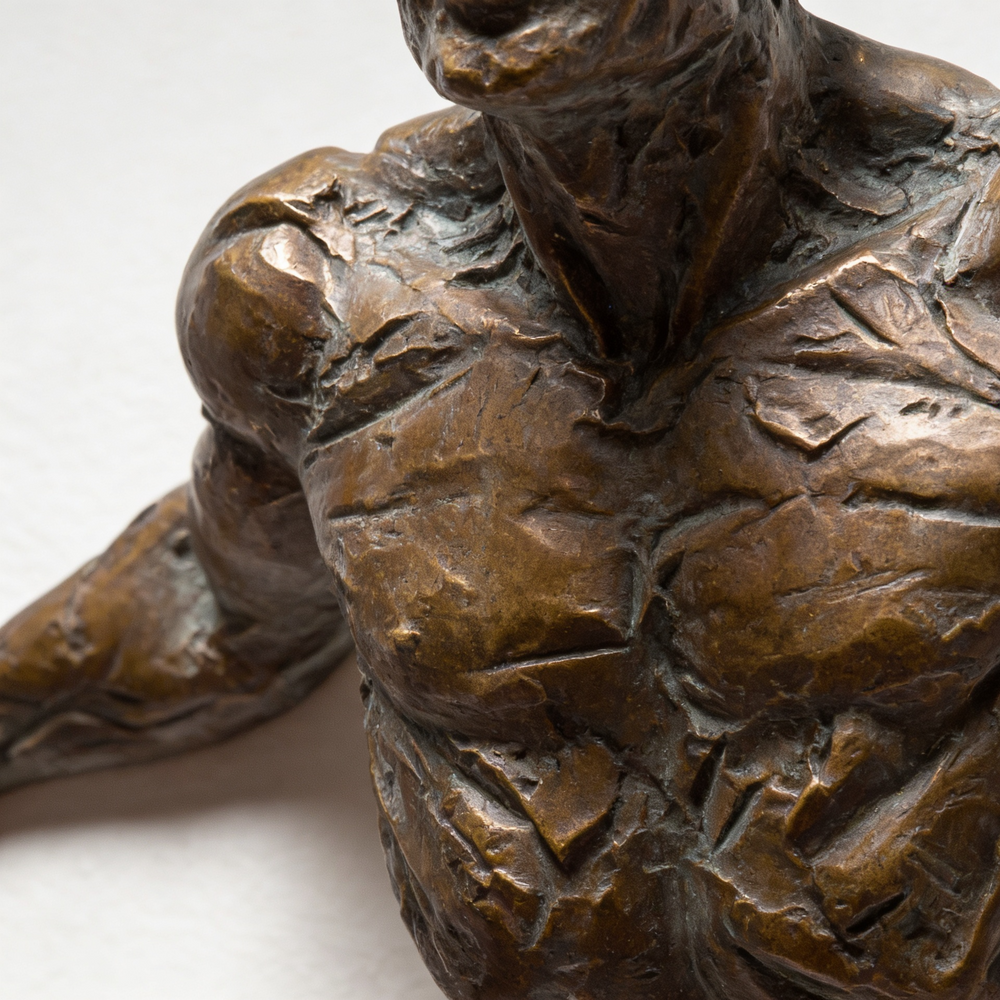 Bronze sculpture of a person holding a child on a white background