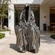 Statue of a hooded figure in front of a modern building
Bronze artwork featuring a hooded figure with deep folds and shadows