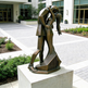 Bronze sculpture of a couple embracing in front of a building
