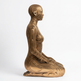 Bronze sculpture of a stylized human figure on a white background