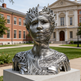Metallic sculpture of a face in front of a building

Fragmented abstract bust created from smooth metallic ribbons forming a textured human profile