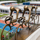 Bronze sculpture of cyclists on a track with a stadium in the background