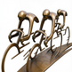 Bronze sculpture of three cyclists in a line on a white background