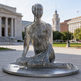Contemporary seated figure sculpture with open, layered metal construction