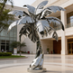 Shiny metallic palm tree figure with broad angular leaves and a twisted reflective trunk