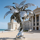 Polished steel‑like palm tree sculpture with sculpted leaves and a spiraling trunk design