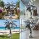 Outdoor polished metal sculpture of a palm tree with sharp‑edged reflective leaves