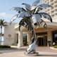 Modern reflective palm tree sculpture with a twisted trunk and smooth metallic leaf shapes