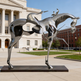 Metallic sculpture of a horse in front of a building