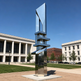 Polished metal sculpture featuring stacked geometric shapes with smooth reflective surfaces