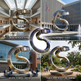 Collage of a large metal sculpture in various settings including a museum, government plaza, school science center, and public park.