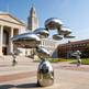 Abstract outdoor sculpture made of ascending metallic pebble forms with mirrored finish