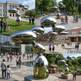Outdoor polished metal installation featuring rounded stacked forms with mirrored highlights