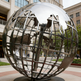 Modern world globe sculpture crafted from polished metal with detailed landmass outlines