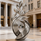 Ornate metal sculpture with stylized leaf forms and symmetrical engraved swirl designs