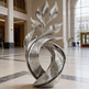 Decorative metal sculpture in a large, open hall with high ceilings and large windows.