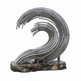 A modern wave sculpture made of curved metallic tubes mounted on a rough stone base, photographed against a plain white background.