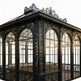 Wrought iron sunroom with decorative scrollwork and tempered glass panels