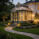 Orchard house with a large glass conservatory at dusk