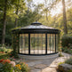 Freestanding glass gazebo with black metal frame and finial