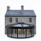 Stone house with a large glass orangery extension on a white background