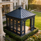 Black garden gazebo in a luxurious garden setting with a mansion in the background