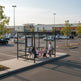 Empty modern shopping cart shelter with flat slatted roof and glass enclosure designed for grocery and retail stores.