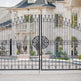 A beautiful driveway gate and a Canadian mansion in the background.