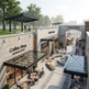 Outdoor shopping area with coffee shop, market, and public plaza.