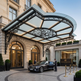 Luxury car parked in front of a grand hotel entrance with decorative canopy