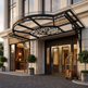 Luxury hotel entrance with decorative canopy and luggage cart