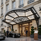 Luxury hotel entrance with ornate canopy and cars parked outside