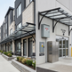 Row of townhouses with a focus on a residential entrance and delivery zone area.