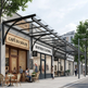 Street view of a row of shops including Café du Soleil, Boutique Clothing, and Gentry's Salon.
