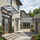 Modern house exterior with decorative awnings and landscaping