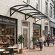 Street view of a quaint urban street with shops and pedestrians.
