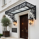 Decorative metal canopy over a door with wall-mounted lights on a white building.